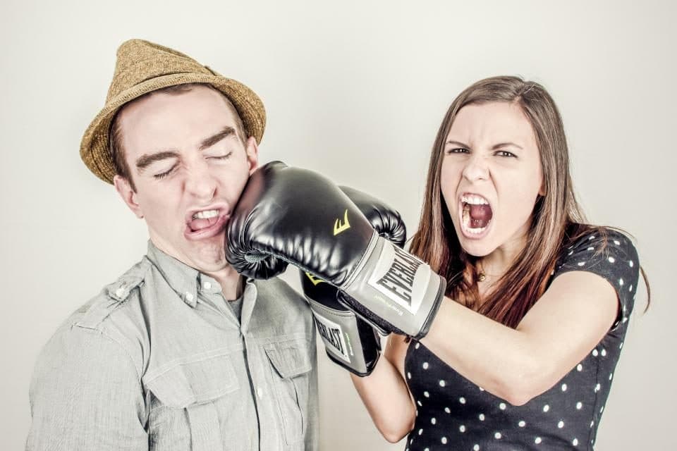 Two people play fighting, one wearing boxing gloves